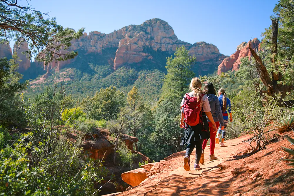 Sedona Vortex Adventures guests enjoying a guided red rock hiking tour with expansive views of the Sedona backcountry.