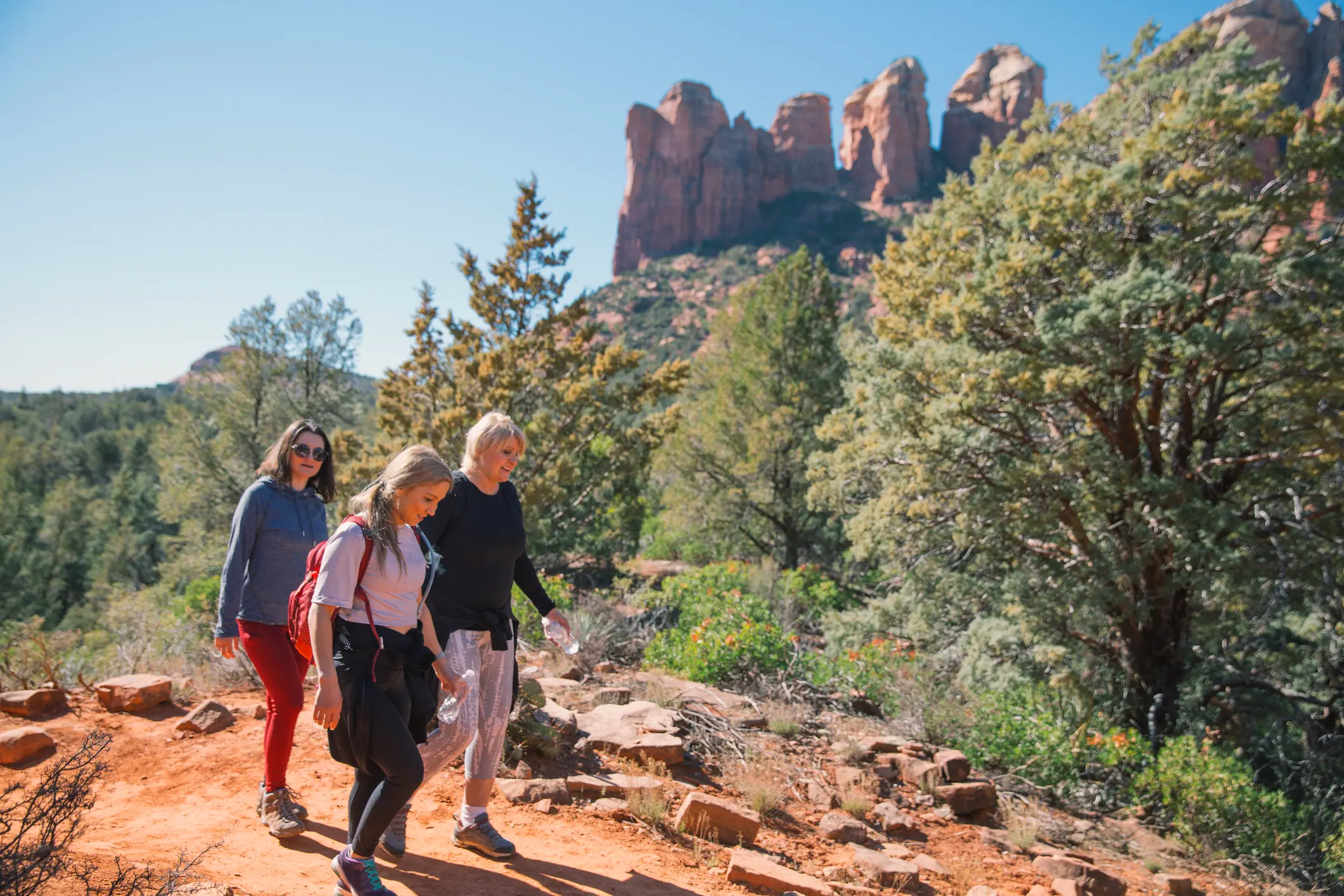 Sedona Vortex Adventures clients enjoying a guided red rock hiking tour near Chimney Rock in Sedona, Arizona.